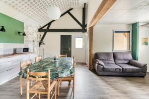 une salle à manger avec une table et un canapé dans l'établissement Gîte Ruelle aux Vaches - Avec piscine partagée, à Montreuil-Bellay
