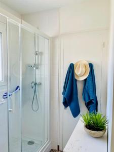 uma casa de banho com um chuveiro com uma toalha azul e um chapéu em Vue Mer La Baule : Le Castel d'Armor em La Baule