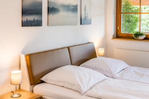 een bed in een slaapkamer met 2 lampen en een raam bij Der Bradler in Ebhausen