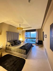 a bedroom with a large bed and a chandelier at Saphir penthouse ocean view in Casablanca