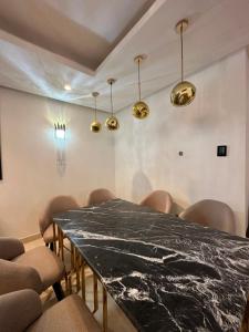 a dining room with a black marble table and chairs at Saphir penthouse ocean view in Casablanca