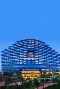 a large blue building with a lot of windows at Sheraton Zhuhai Hotel in Zhuhai