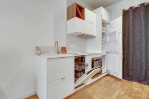 La cuisine est équipée de placards blancs et d'un four. dans l'établissement Magnifique Appart 2-4 pers Quartier Latin WIFI, à Paris
