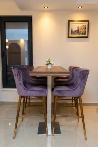 a dining room table with purple chairs at Merak Rooms & Caffe Bar in Šabac