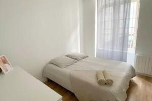 ein weißes Schlafzimmer mit einem Bett und einem Fenster in der Unterkunft Bel appartement neuf et facile d'accès in Orléans