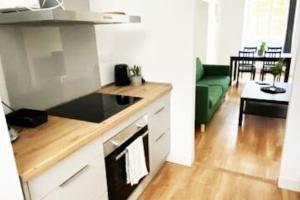 eine Küche mit Herd Top-Backofen neben einem Wohnzimmer in der Unterkunft Bel appartement neuf et facile d'accès in Orléans