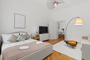 een witte slaapkamer met een bed en een woonkamer bij Cozy Vienna Apartments - 4 Min U6 Josefstädterstraße in Wenen
