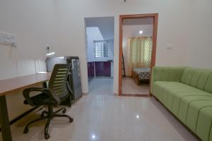 a living room with a couch and a desk and a chair at HomeSlice Manzil - 1BHK in HSR in Bangalore