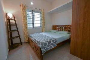 a bedroom with a bed with a ladder and a window at HomeSlice Manzil - 1BHK in HSR in Bangalore +14 photos