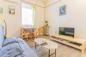 a living room with a couch and a tv and a table at Plage des catalans appart 4 personnes in Marseille