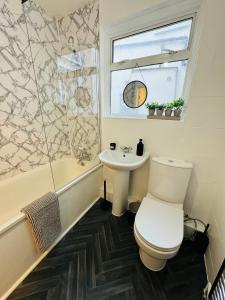 a bathroom with a toilet and a sink at 2 Bedrooms House near Central London in London