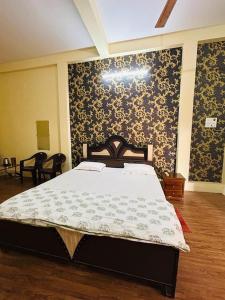 Schlafzimmer mit einem Bett mit einer schwarzen und goldenen Tapete in der Unterkunft RN Residency in Varanasi