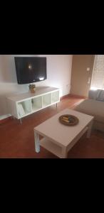 sala de estar con TV y mesa de centro blanca en Piso en pleno centro, cerca de Sevilla, en Alcalá de Guadaira