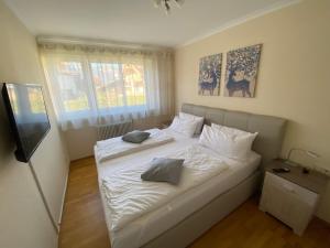 een slaapkamer met een wit bed met 2 kussens erop bij Amici in Garmisch-Partenkirchen