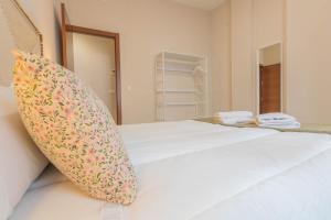 - une chambre avec un grand lit blanc et un oreiller dans l'établissement APARTAMENTOS LOS ABUELOS - Cordoba, à Cordoue