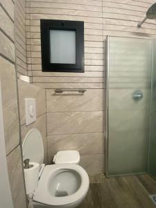 a bathroom with a toilet and a tv on the wall at Studio Unit in Ashdod Israel in Ashdod