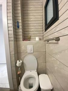 a small bathroom with a toilet and a window at Studio Unit in Ashdod Israel in Ashdod