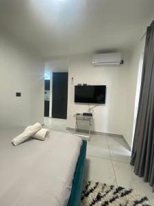 a white room with a bed and a tv at Studio Unit in Ashdod Israel in Ashdod