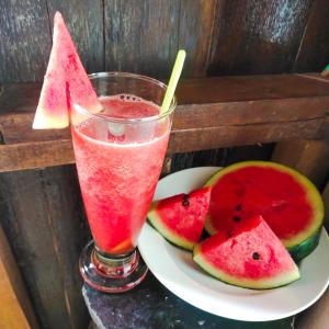 a plate with a drink and some slices of watermelon at Poohry Seaview in Ko Lanta