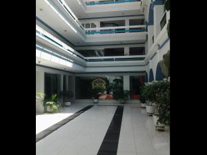 a large hallway with potted plants in a building at Luz Palace Hotel in Tarija