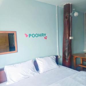 ein Schlafzimmer mit einem Bett mit einem Keramikschild an der Wand in der Unterkunft Poohry Seaview in Ko Lanta