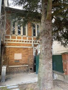 a brick building with a bench next to a tree at Appartement 4 chambres spacieux et lumineux in Orléans