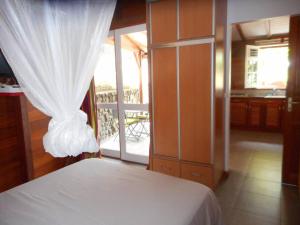 布雍特的住宿－Ti Chalet à Malendure Bouillante，一间带白色床的卧室和一个阳台