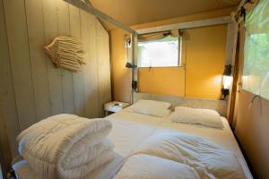 een kleine kamer met een bed in de hoek bij Camping Vossenberg - op de Veluwe! in Epe