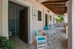 Une porte ouverte s'ouvre sur une terrasse avec une table et des chaises. dans l'établissement Villa Areti, à Astrakeri