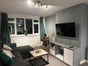 a living room with a couch and a flat screen tv at Charming 2-Bed Apartment in the Heart of Leeds in Leeds