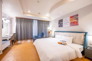 a hotel room with a large bed and a desk at Wenpin Hotel - Pier 2 in Kaohsiung