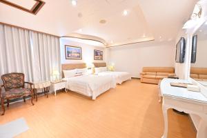 a hotel room with two beds and a desk at Wenpin Hotel - Pier 2 in Kaohsiung