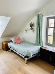 um quarto com uma cama e uma janela num sótão em Face Mer Villa Le Petit Breton em Pornichet