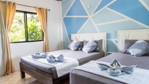 two beds in a room with blue walls at DolceVita Wonderful Resort in Ko Lanta