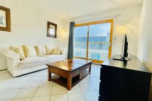 a living room with a couch and a table with a television at Ar ranndi in Camaret-sur-Mer
