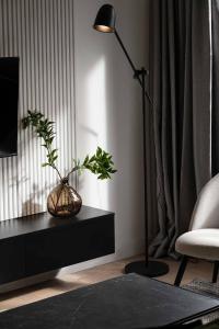 a living room with a lamp and a table with plants at ZEST Verde in Kragujevac
