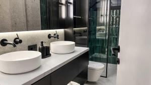 a bathroom with two sinks and a glass shower at ZEST Verde in Kragujevac