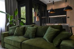 a green couch in a living room with a kitchen at ZEST Verde in Kragujevac +20 photos