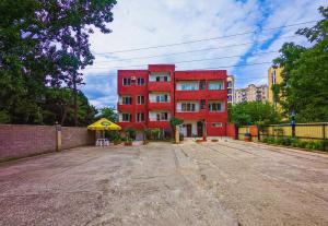 un edificio rosso nel mezzo di un parcheggio di Tbilisi Airport Hotel - ATU a Tbilisi City
