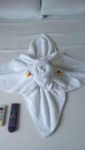 a white towel on a bed next to a remote control at Pousada Vilas Boas in Barreirinhas +58 photos