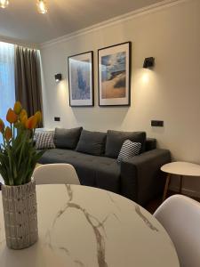 a living room with a couch and a table at Sun Clock Apartment in Šiauliai