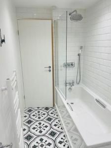 a white bathroom with a shower and a tub at Vine Cottage- Stunning newly renovated cottage 