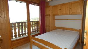 ein Schlafzimmer mit einem Bett und einem Balkon in der Unterkunft Appartement Yeti Immobilier 2 in Thollon