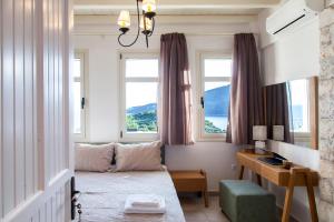 a room with a bed and a desk and windows at Sivota Villas with Sea Access in Sivota