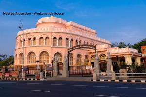 een groot roze gebouw aan de kant van een straat bij Capital O Admire Suit Hospitality in Chennai