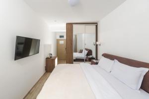 ein Hotelzimmer mit einem Bett und einem TV in der Unterkunft Hotel 219 Budva in Budva