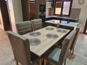 a wooden table with four plates on it in a kitchen at Mahdia - Baghdadi - Laourient Apartments, restaurant, café in Mahdia
