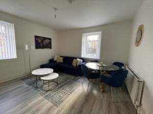 a living room with a blue couch and a table at Stunning 2-Bed Apartment in Greenock - Sleeps 6 in Greenock