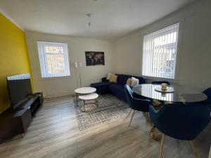 - un salon avec un canapé bleu et une table dans l'établissement Stunning 2-Bed Apartment in Greenock - Sleeps 6, à Greenock