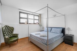 una camera con letto a baldacchino e sedia di POM10 -Loreto - Duomo- 5 minutes from the Duomo a Milano